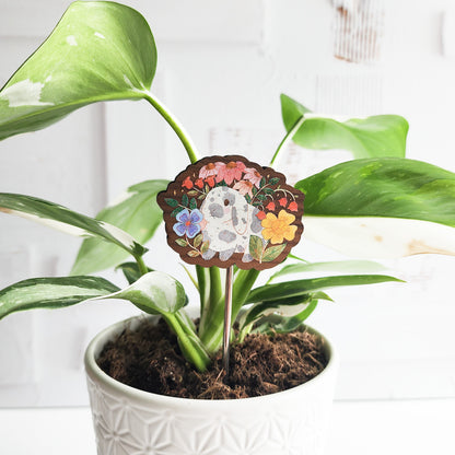 Decorative plant stake with a rabbit floral design in a pot against a white background