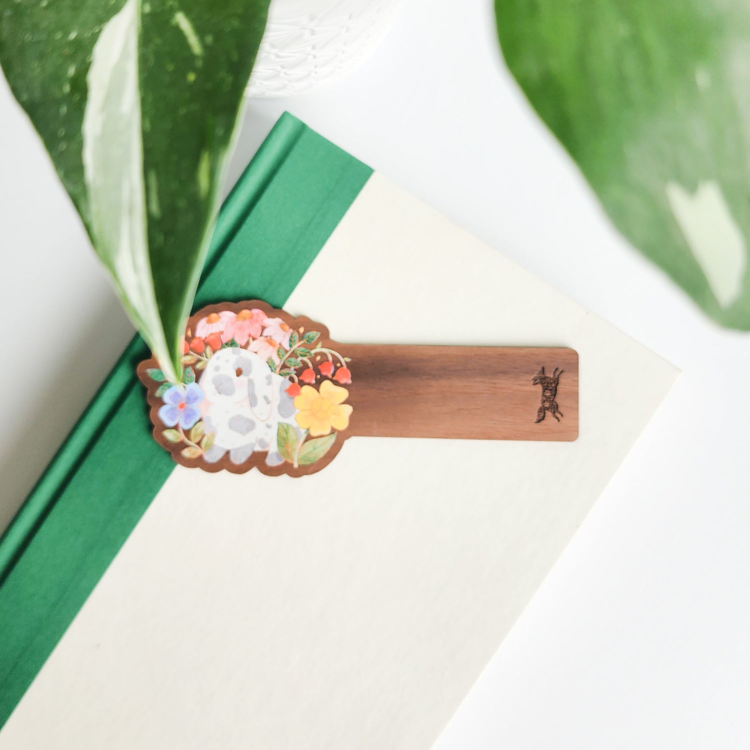 floral bunny bookmark sitting on a green and white bookmark on a white background with leaves
