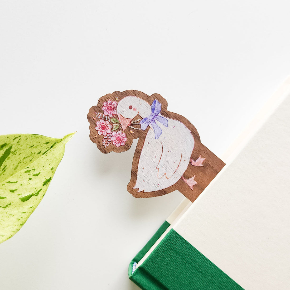 wooden bookmark with the image of a goose holding a bouquet