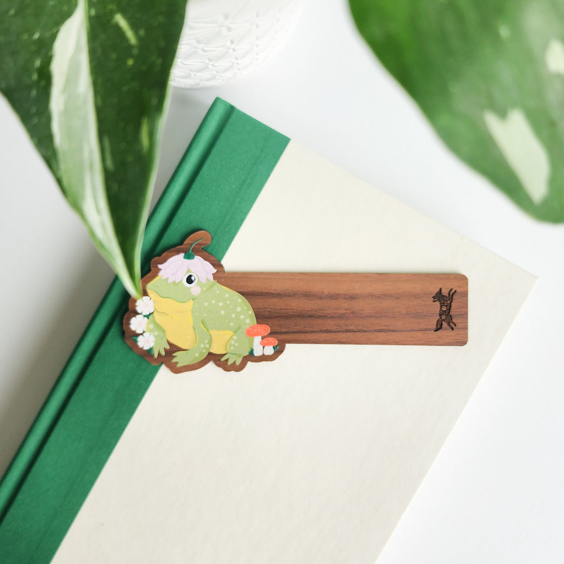 toad bookmark on a green and white book on a white background with leaves