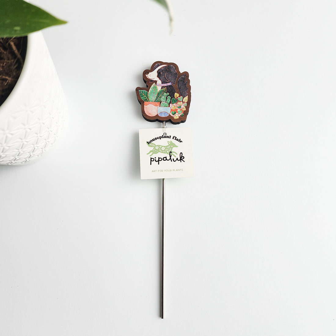 dog decorative plant stake with a pipaluk tag on a white background