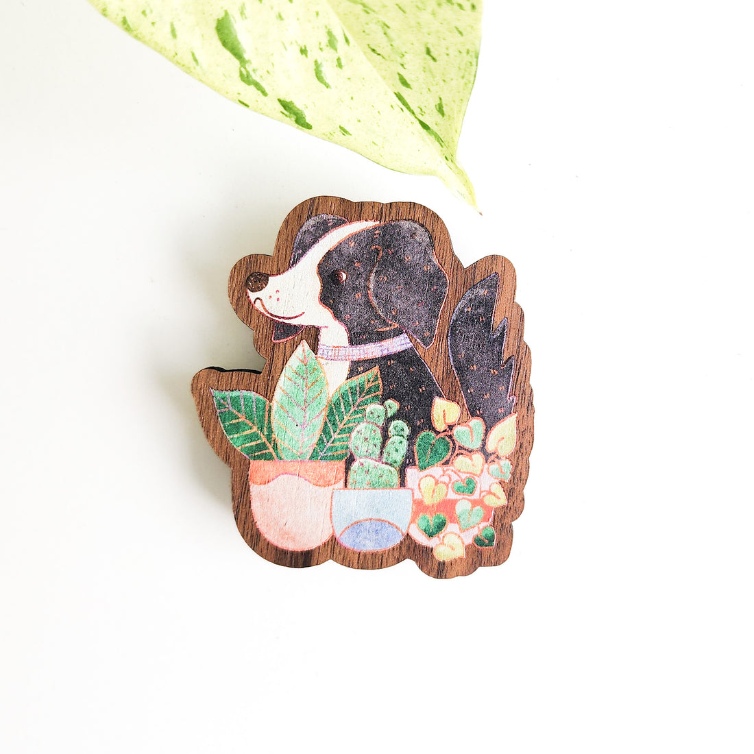 dog and houseplant magnet on a white background with a leaf
