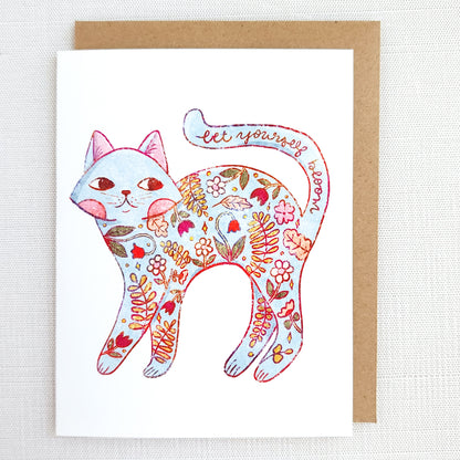 Greeting card with a colorful cat illustration and floral patterns on a white background.