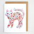 Greeting card with a colorful cat illustration and floral patterns on a white background.