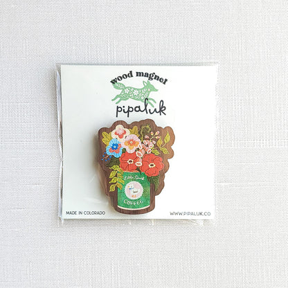 Wooden magnet with an illustrated Little Duck Coffee can repurposed as a vase, filled with cheerful pink, yellow, and blue flowers in Pipaluk branded packaging on a neutral background