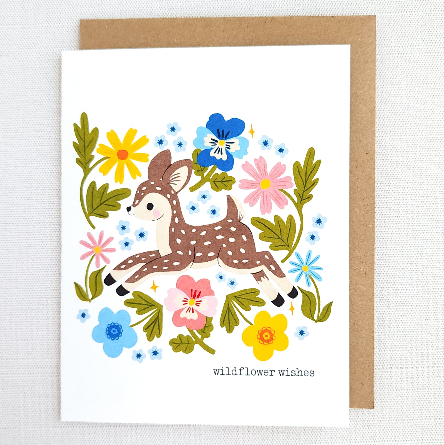Greeting card with a deer illustration surrounded by flowers on a white background