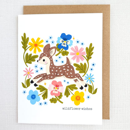 Greeting card with a deer illustration surrounded by flowers on a white background