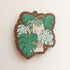 wooden magnet with an image of a cat in a monstera plant on a linen background