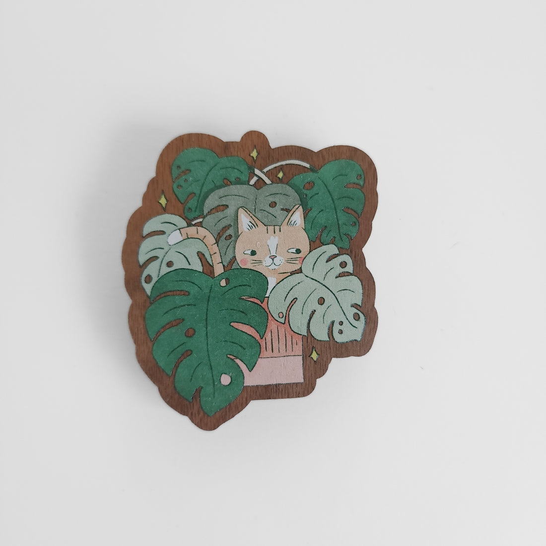 magnet with an image of a sassy yellow cat hiding in a monstera plant