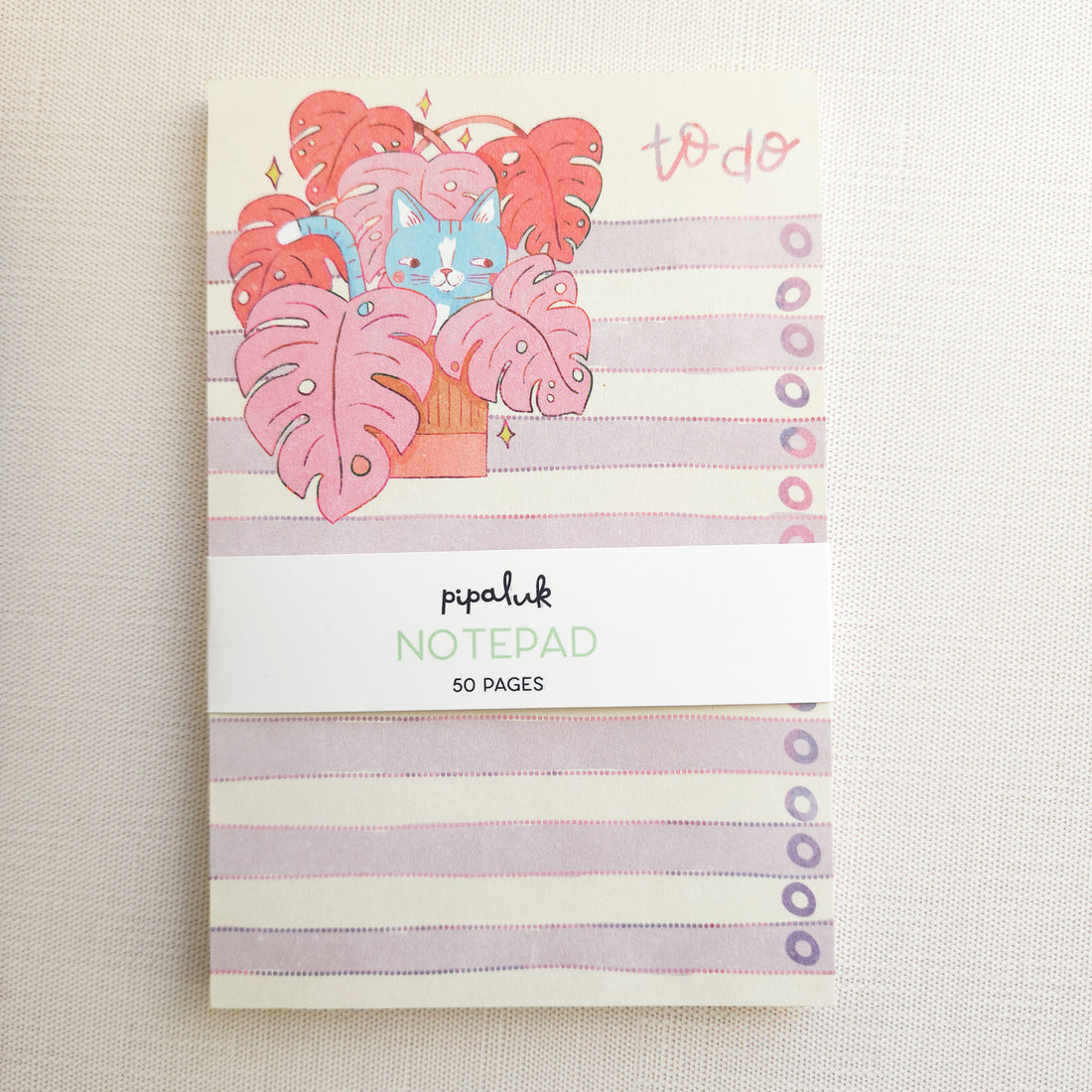 notepad with a cat in a monstera illustration on a white background
