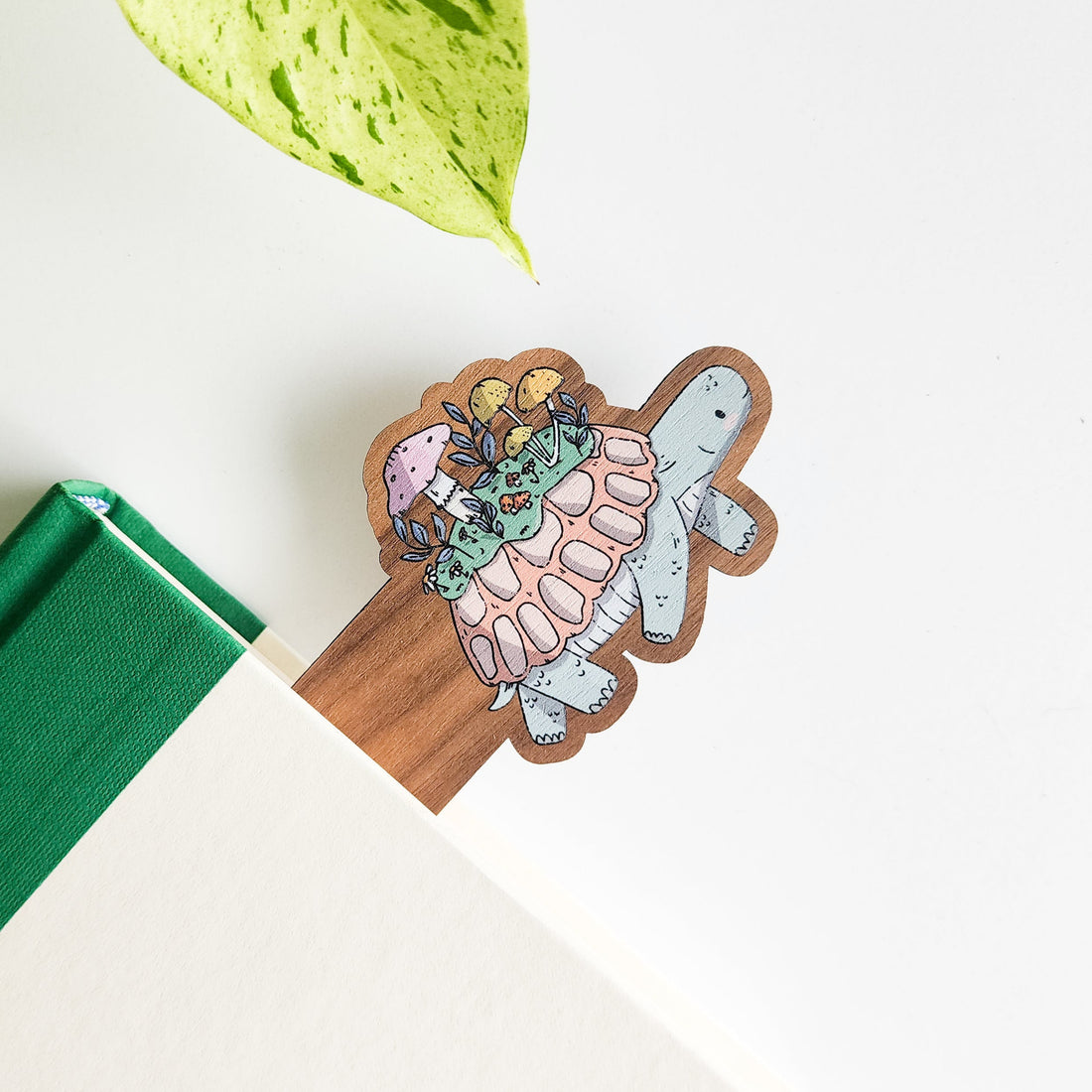Decorative wooden bookmark with a colorful design of a turtle on a book