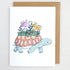 Greeting card with a turtle illustration carrying plants and mushrooms on its shell and the words grow at your own pace
