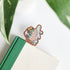 Decorative turtle-shaped bookmark on a book with green leaves in the background