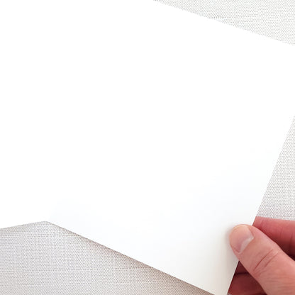 Hand holding an open blank greeting card on a white background
