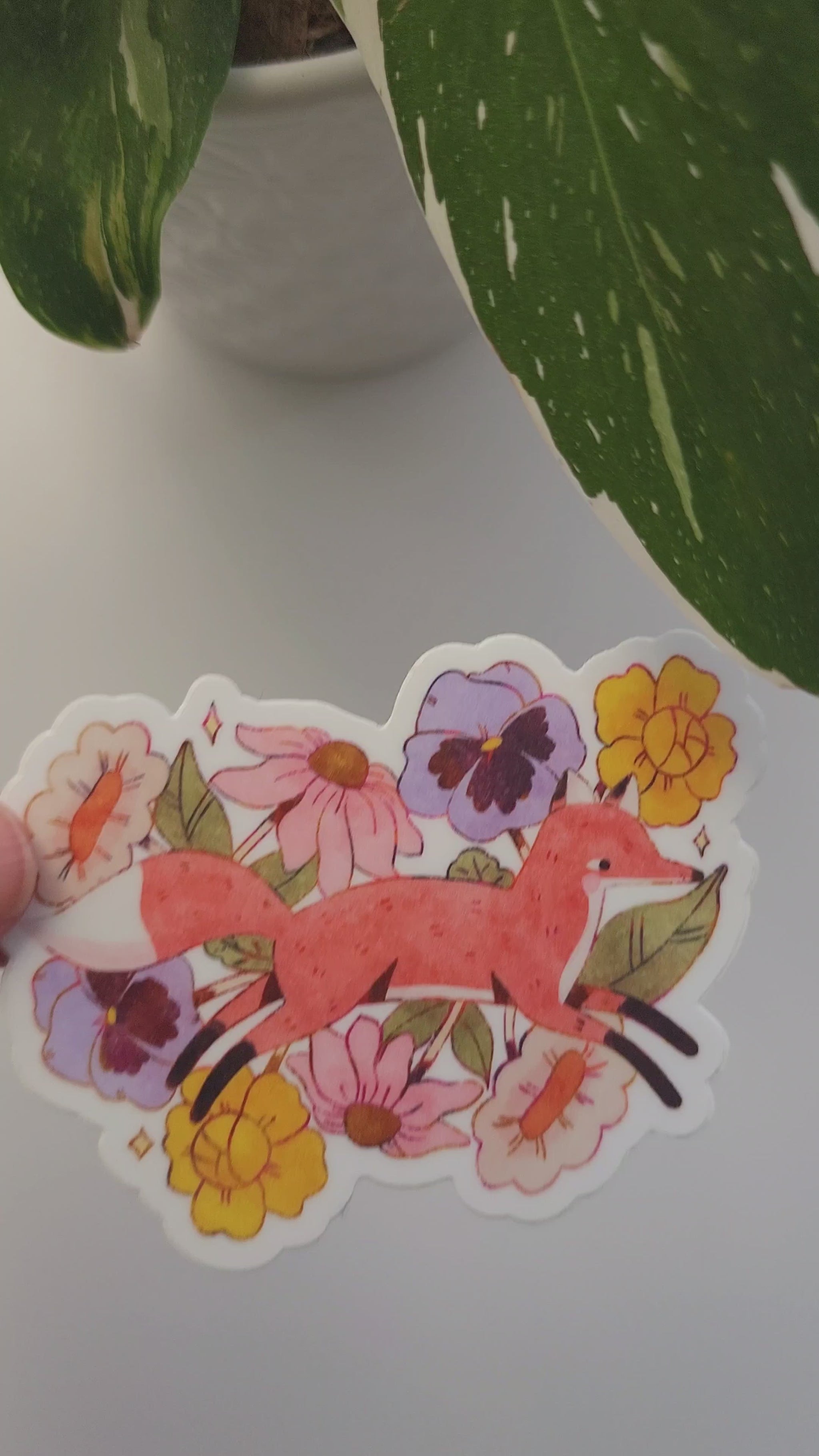 video of fox in blooms sticker held by a plant