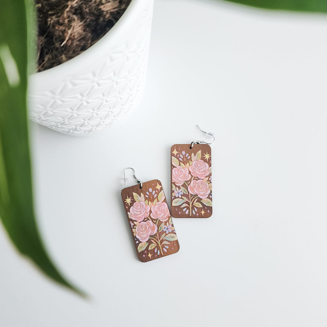 rose bouquet earrings on a white background with a potted plant