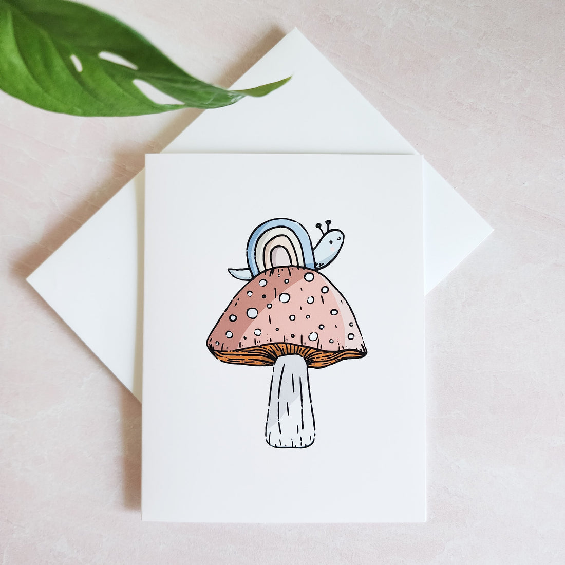 rainbow snail greeting card on top of a white envelope