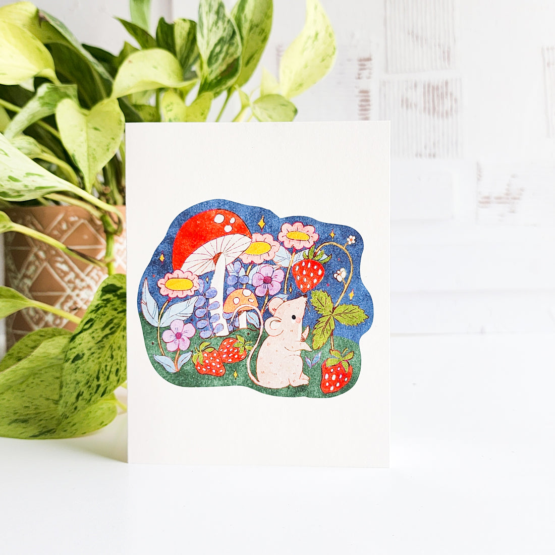 Colorful illustration of a mouse with flowers and mushrooms on a white background on a greeting card