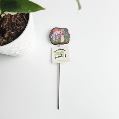 mouse plant pick with a pipaluk tag next to a potted plant on a white background