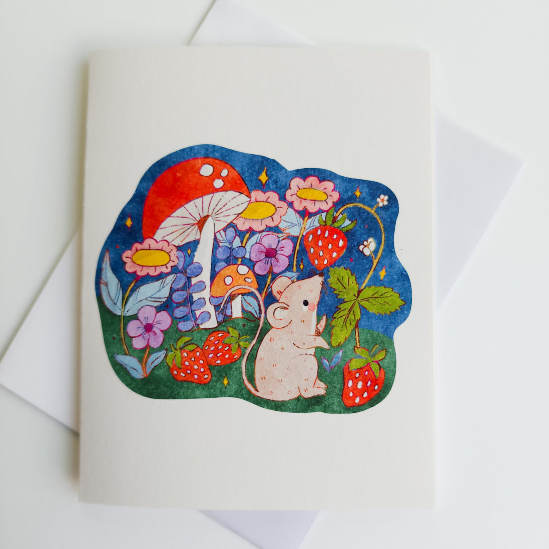 greeting card with the image of a mouse sitting next to a strawberry plant, flowers and a mushroom