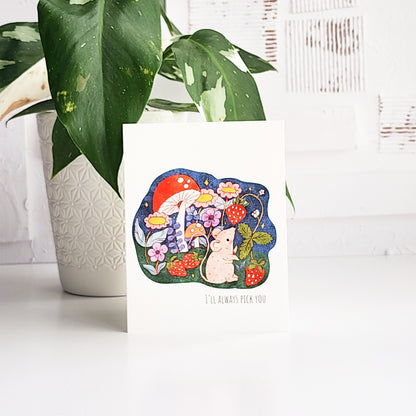 card with a mouse picking strawberries on a white background in front of a plant