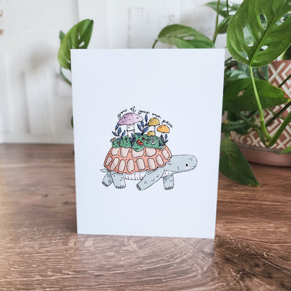turtle greeting card in front of a houseplant