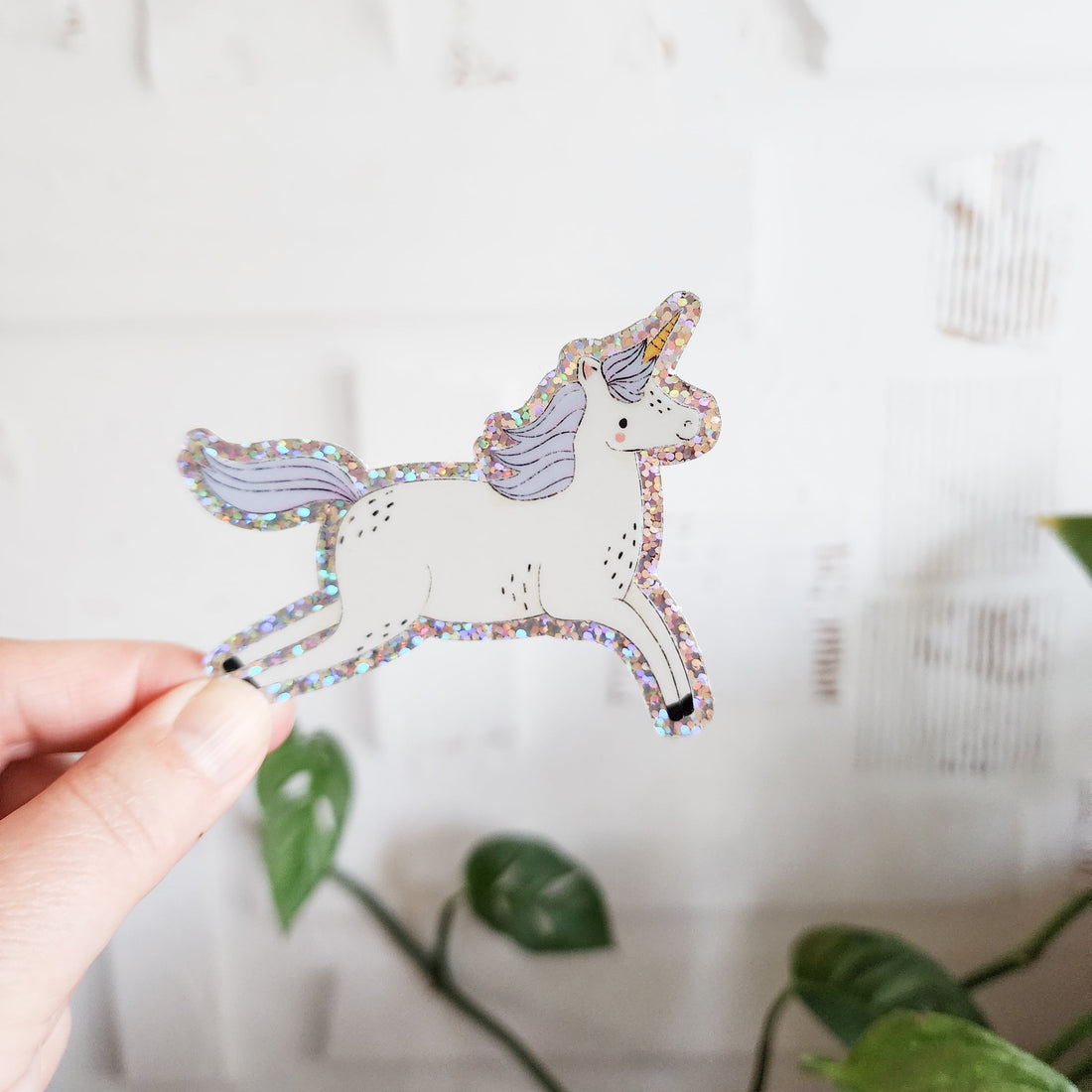 unicorn sticker held in a hand